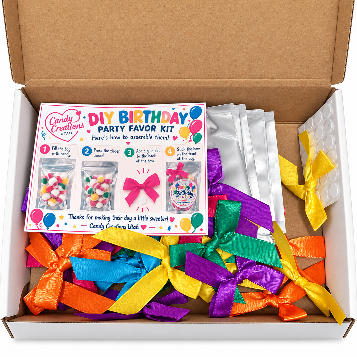 Actual Happy Birthday DIY kit contents in box: empty silver bags, colorful bows, glue dots and one instruction card. Candy not included.