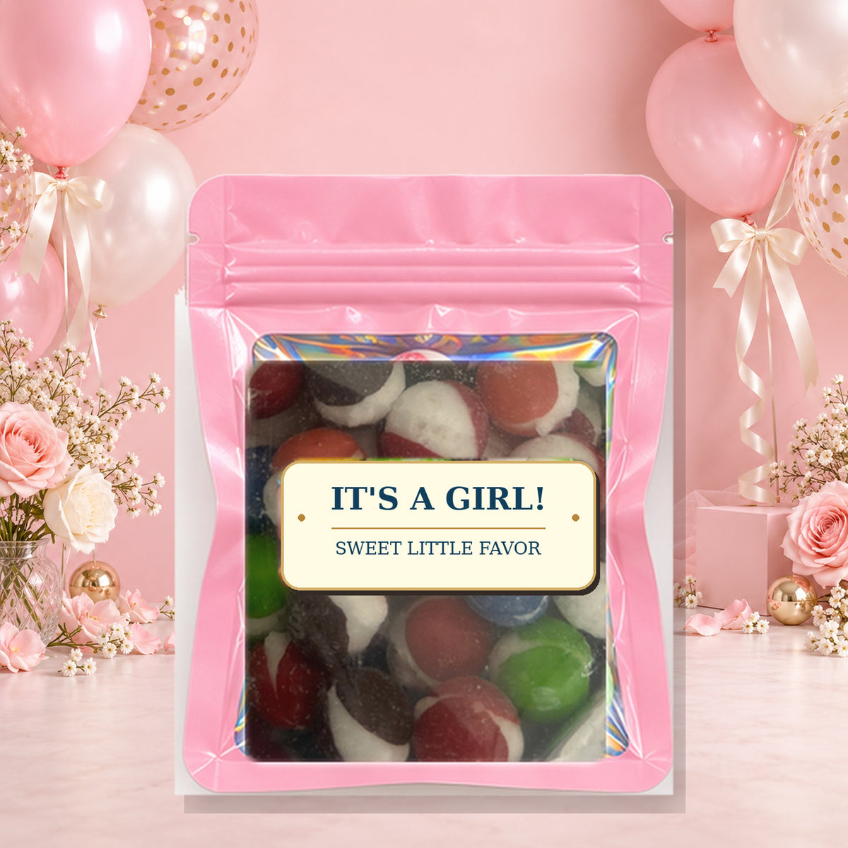 It’s a Girl Assorted Color Party Favors on a pink baby shower background